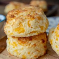 a stack of 2 gluten free cheese scones on a wood cutting board