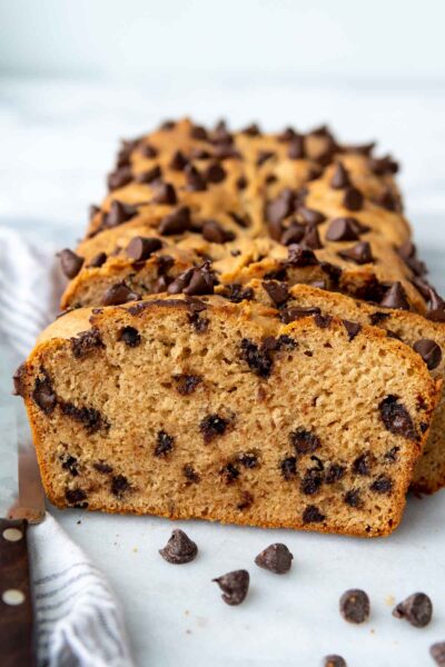 sliced peanut butter chocolate chip bread standing up next to a loaf.