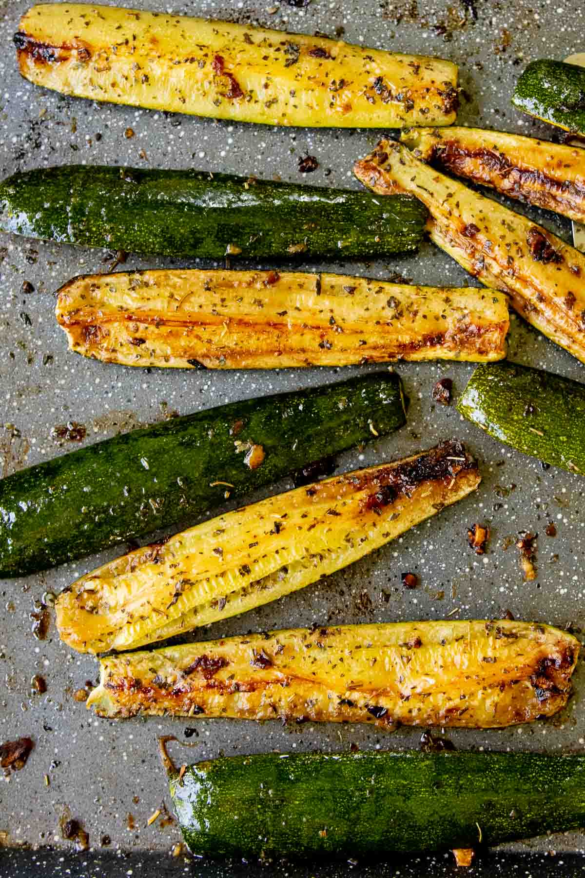close up of roasted zucchini on a sheet pan.