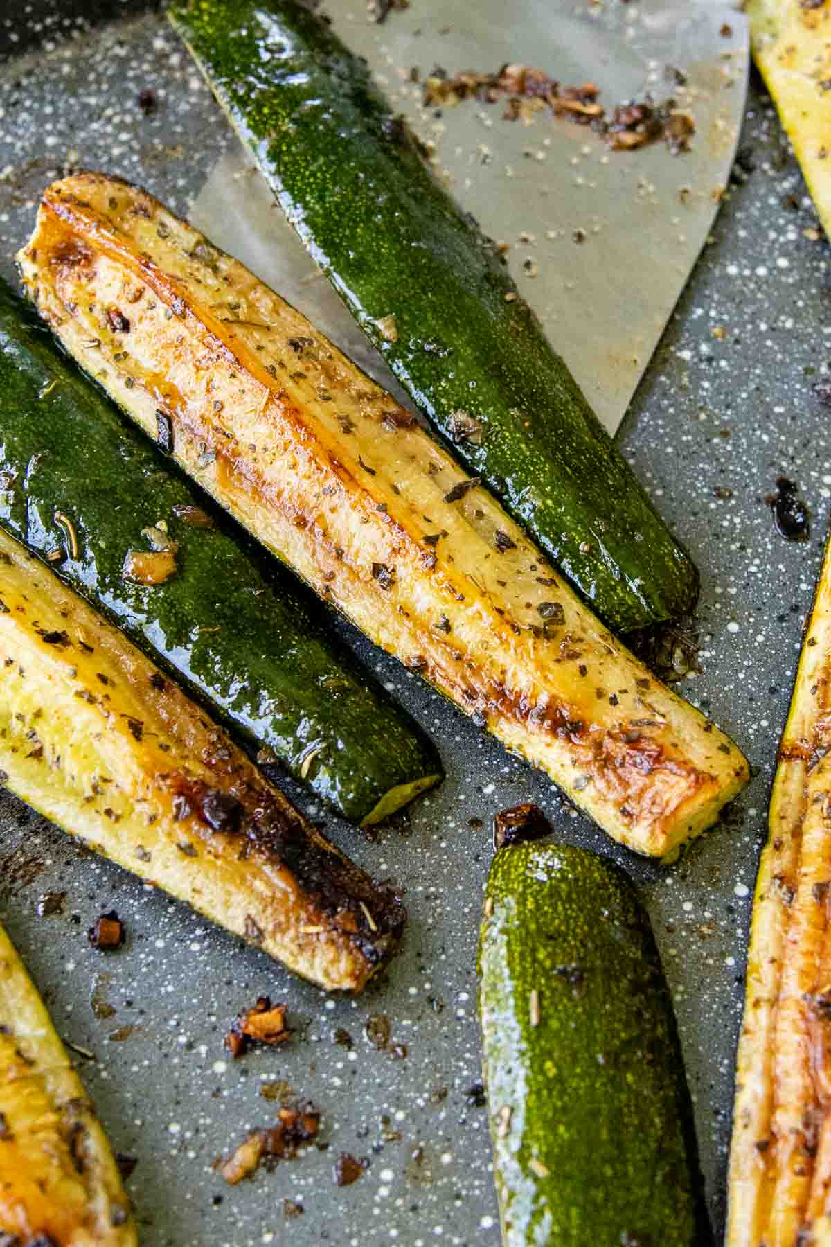 a spatula lifting baked zucchini spears.