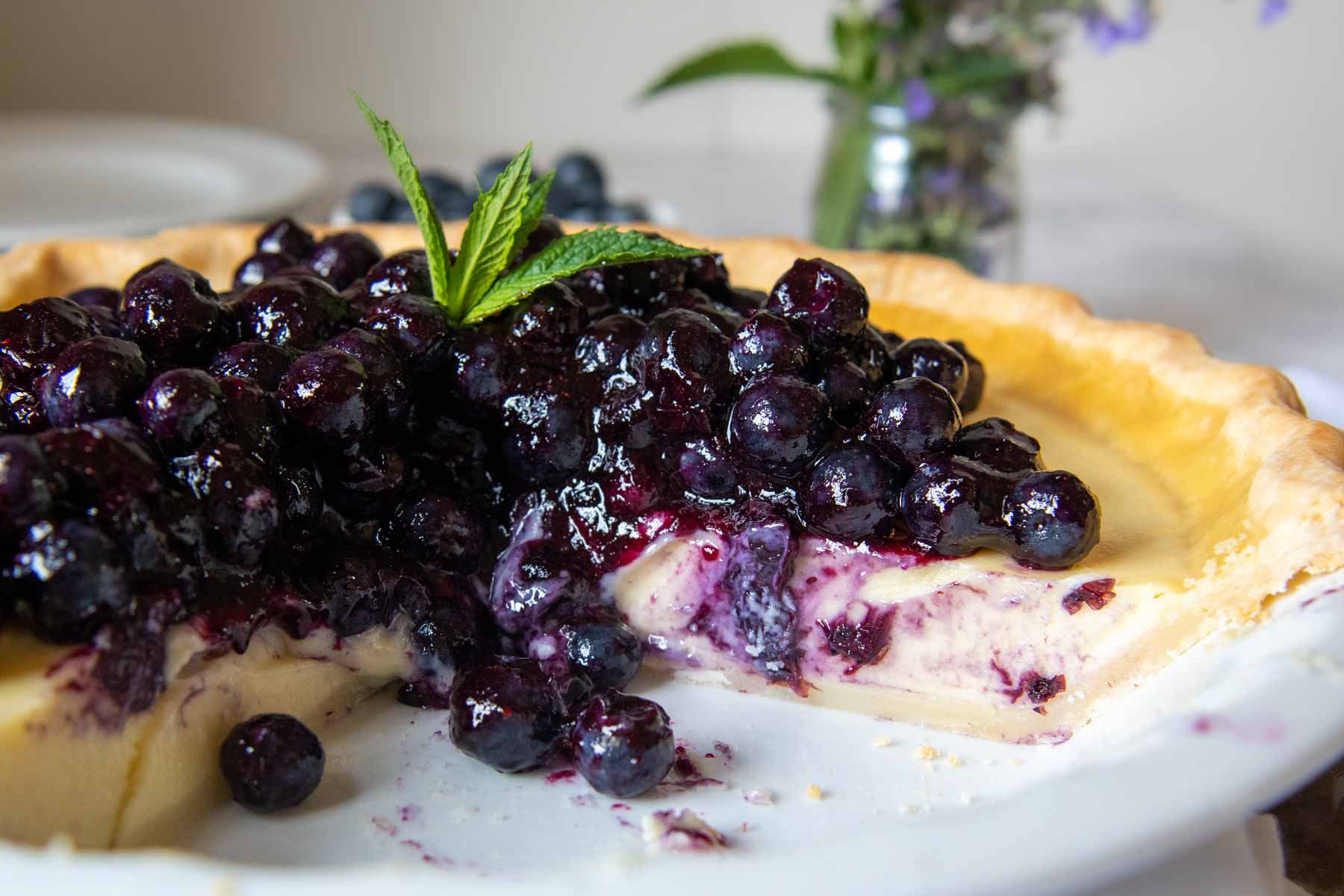 a pie with blueberry topping and slice taken out.