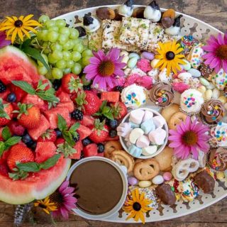 a completed dessert platter with flowers decorating it
