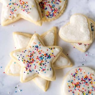 cut out cookies with white frosting and sprinkles