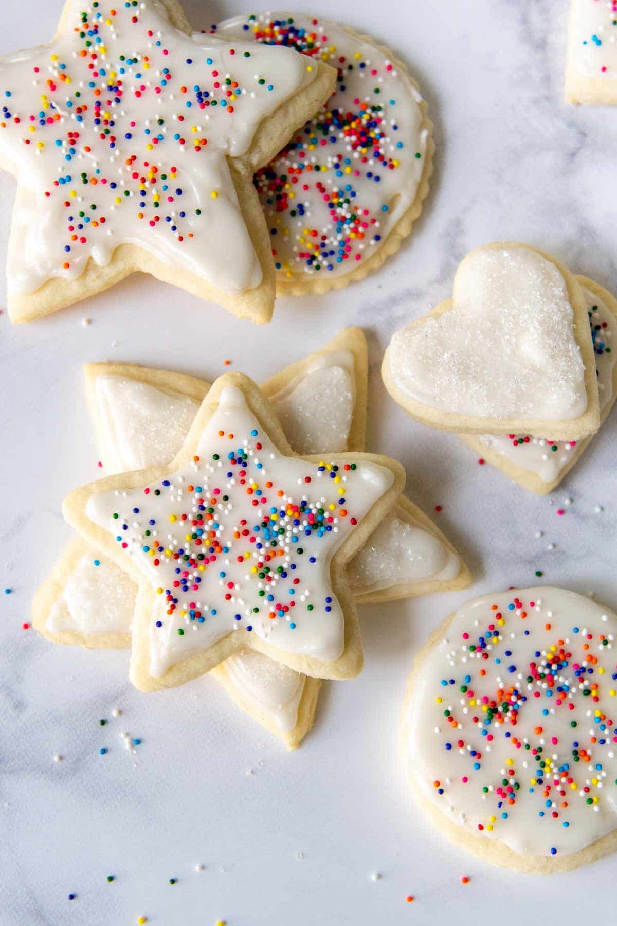 cut out cookies with white frosting and sprinkles