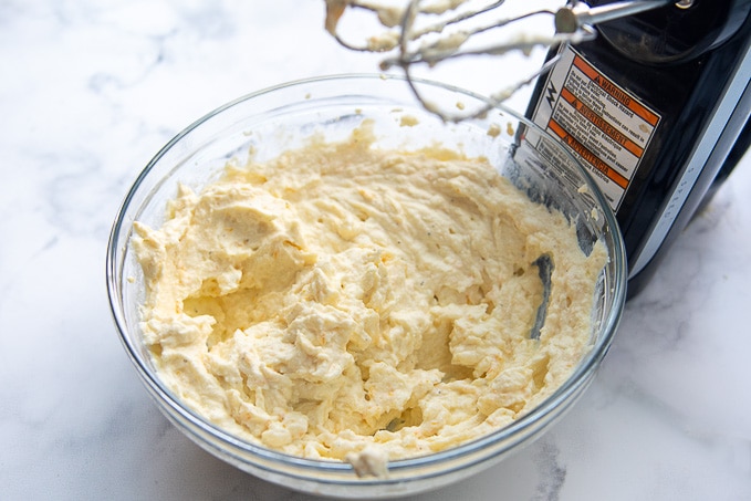 a bowl of honey ricotta dip being beaten with a mixer