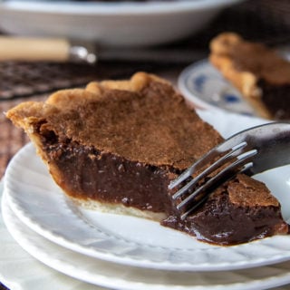 a fork cutting into a piece of chocolate chess pie