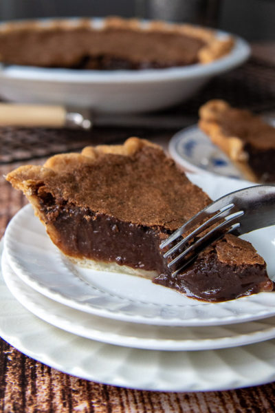 a fork cutting into a piece of chocolate chess pie