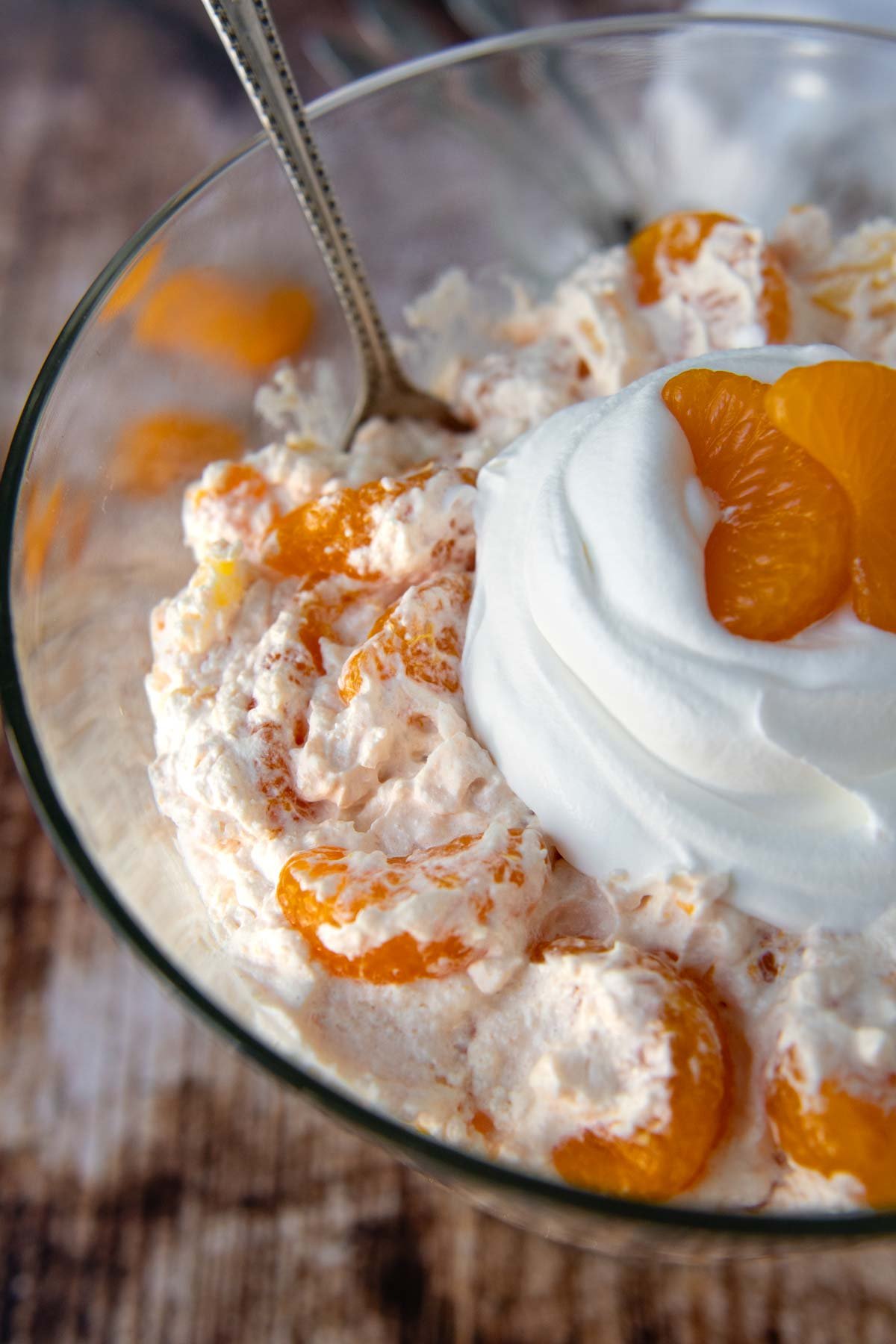 close up of the top of orange fluff with whipped cream on top.