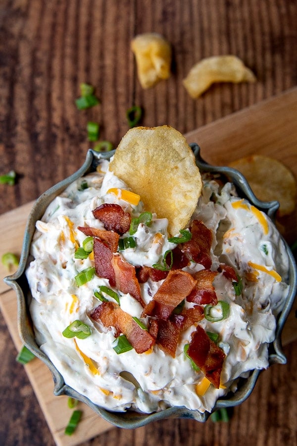 overhead shot of a chip in a bowl of cheddar bacon ranch dip