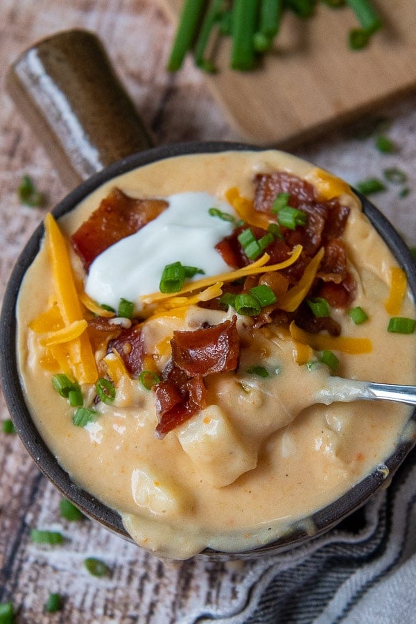 a spoon going into a bowl of potato soup