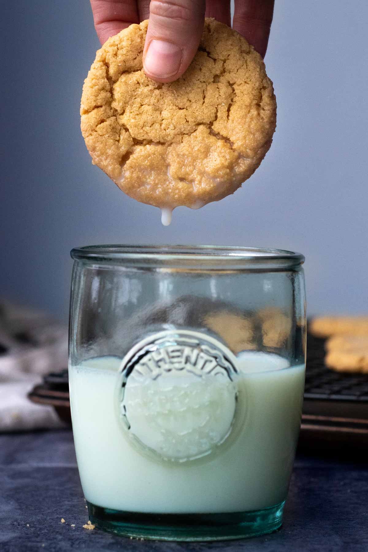 a cookie being dunked into a glass of milk
