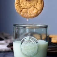 a cookie being dunked into a glass of milk