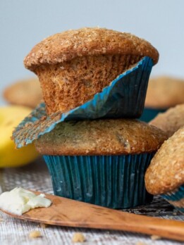 a stack of 2 muffins with a blue muffin paper coming off one