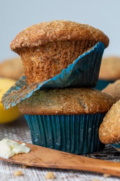 a stack of 2 muffins with a blue muffin paper coming off one