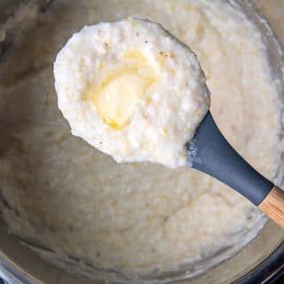 a spoon holding up a scoop of instant pot grits