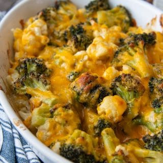 close up of melted cheese on broccoli and cauliflower in a casserole dish