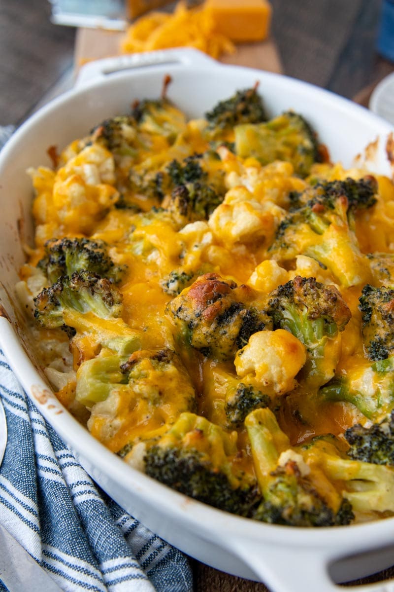 close up of melted cheese on broccoli and cauliflower in a casserole dish