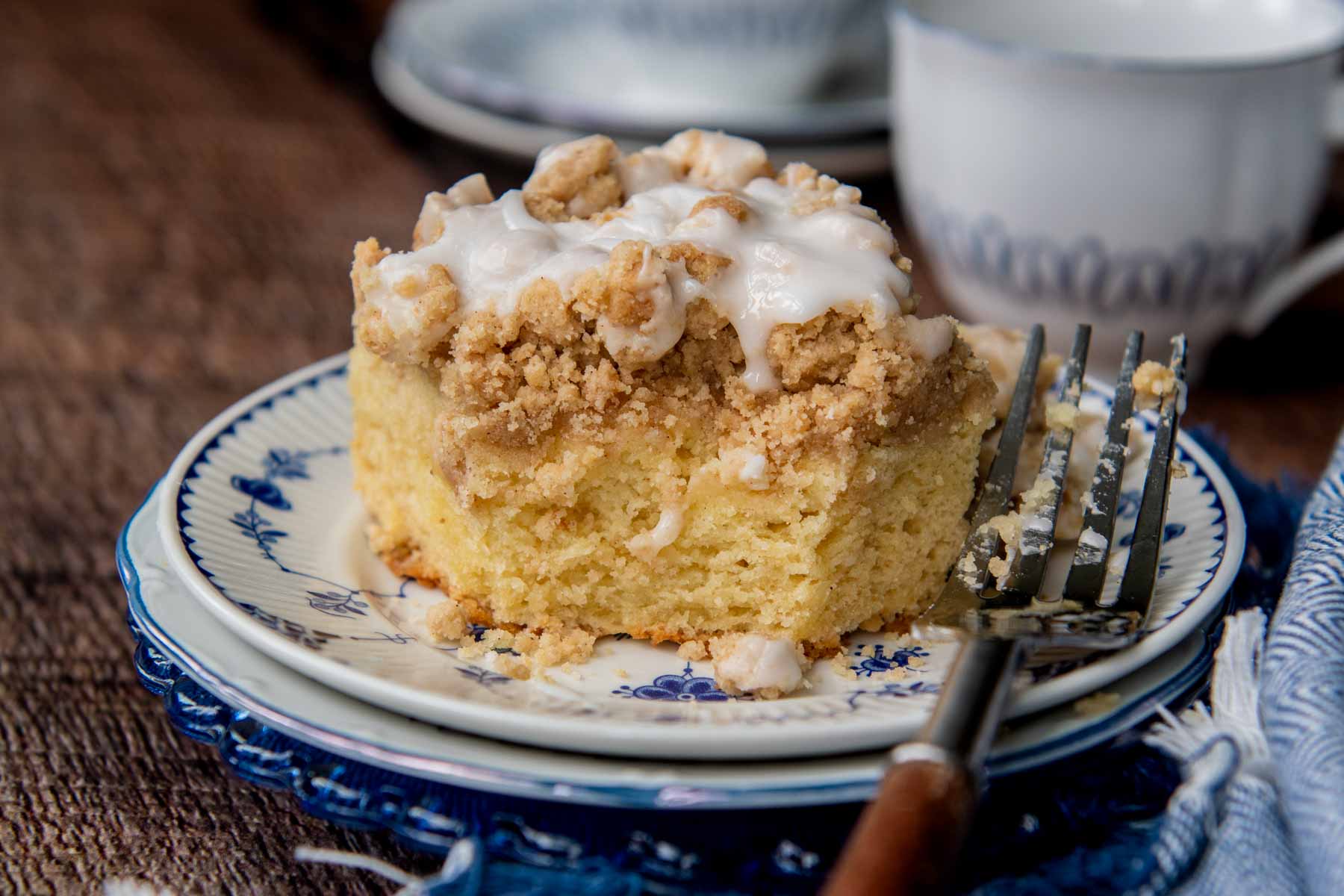 a slice of coffee cake on a blue plate with a bite taken out