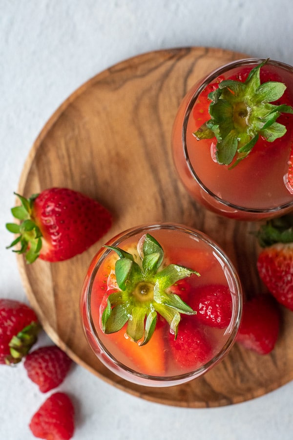 overhead shot of summer berry sangria glasses with fresh strawberries sticking out of glasses