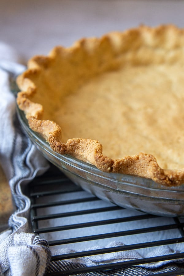 close up of baked almond flour crust in a glass dish