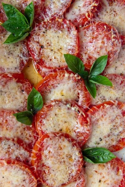 a pan of baked tomatoes with broiled cheese on top