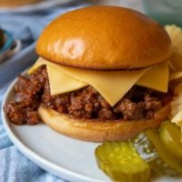 a close up of instant pot sloppy joes on a white plate with two slices of cheese