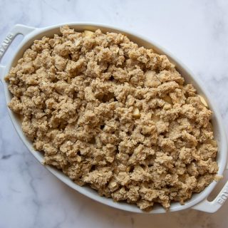 unbaked apple crisp in a while oval dish