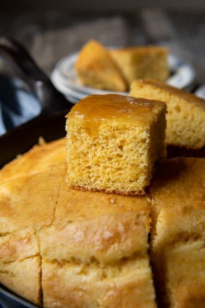 a piece of cornbread sitting on top of ones in an iron skillet