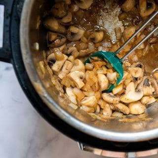 onions and mushrooms beng cooked in an instant pot