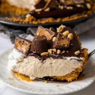 a slice of chocolate peanut butter pie on a white plate with a pie server