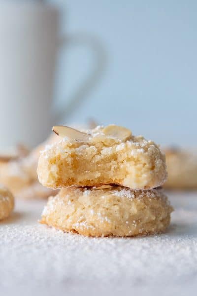 a stack of two almond paste cookies with the top one having a bite taken out
