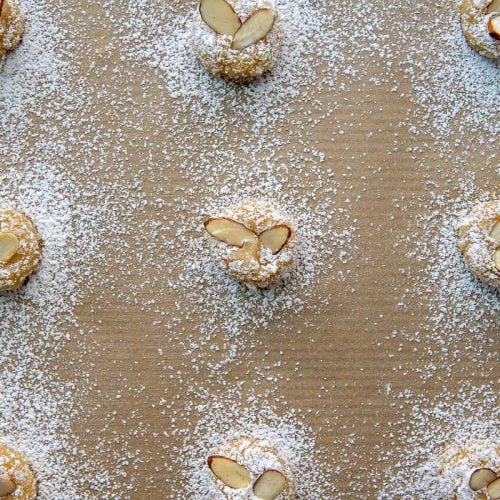 overhead shot of almond cookies with sliced almonds and powered sugar