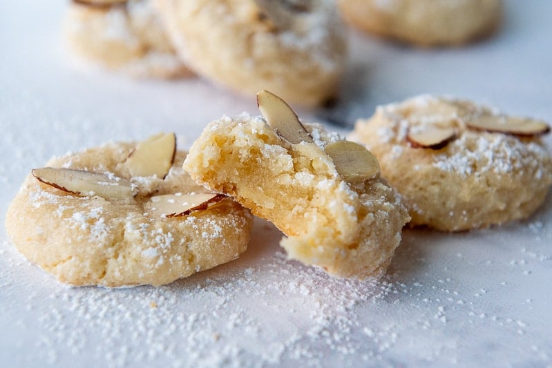 landscape view of two almond cookies with one having a bite taken out