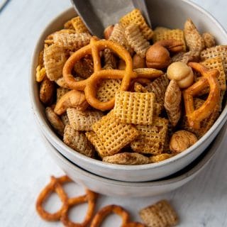 a small bowl of snack mix with a small scoop inside