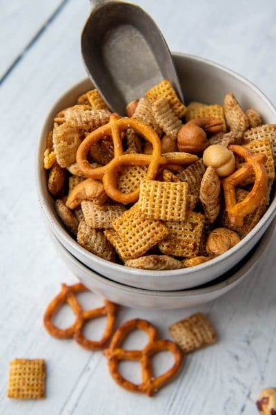 a small bowl of snack mix with a small scoop inside