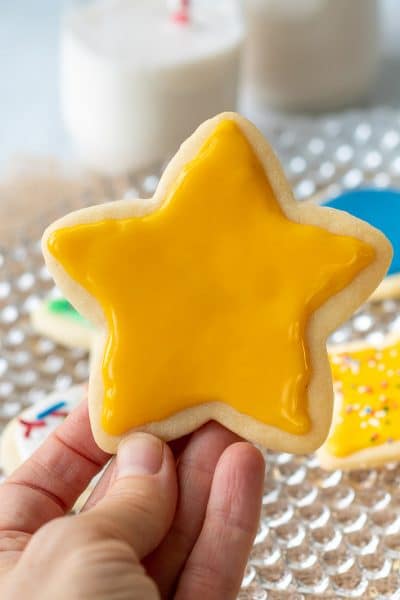 a yellow star sugar cookie being held up