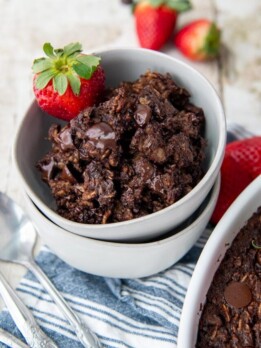 a double stacked bowl of chocolate oatmeal with a blue striped towel underneath