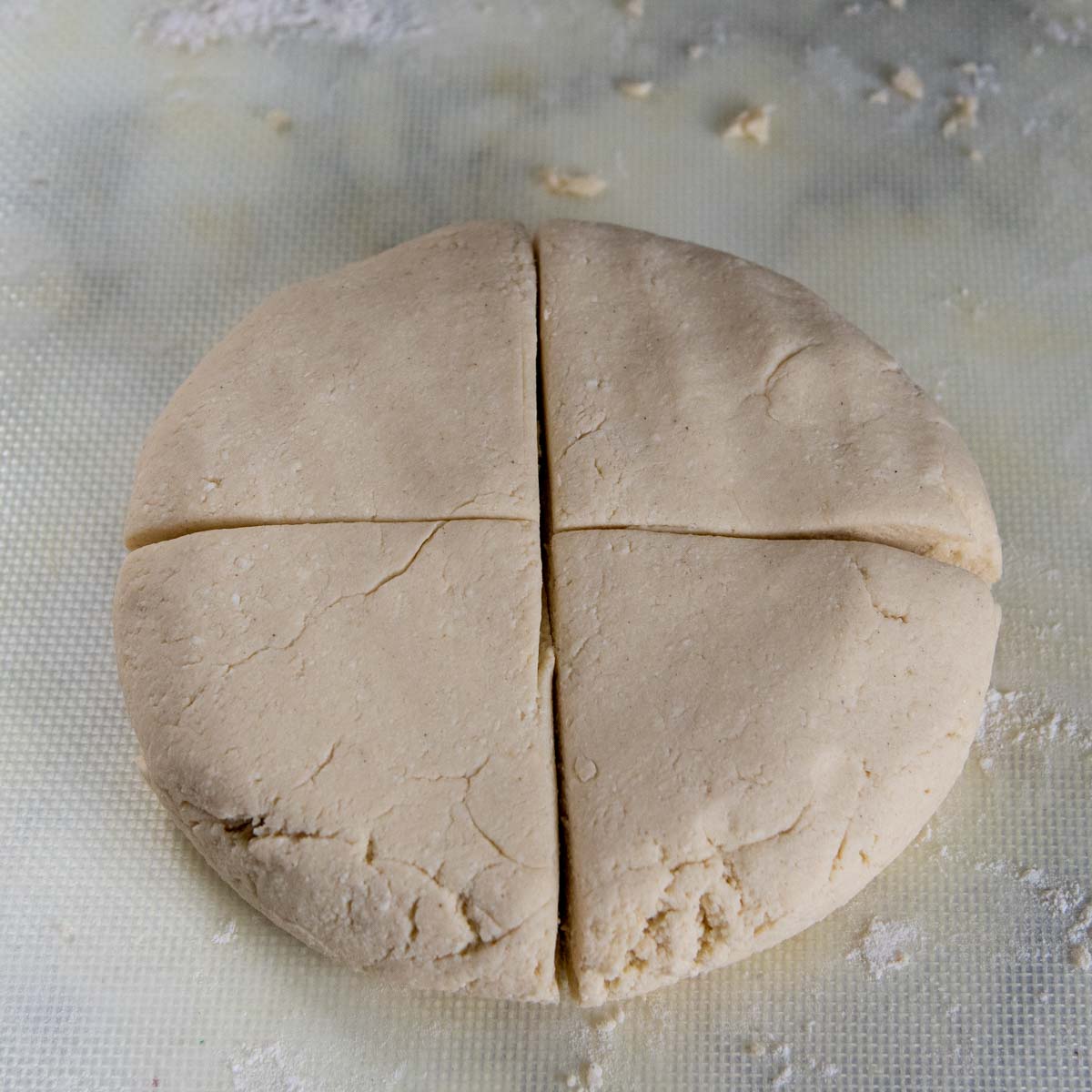 the dough flattened into a disc and cut into fourths.