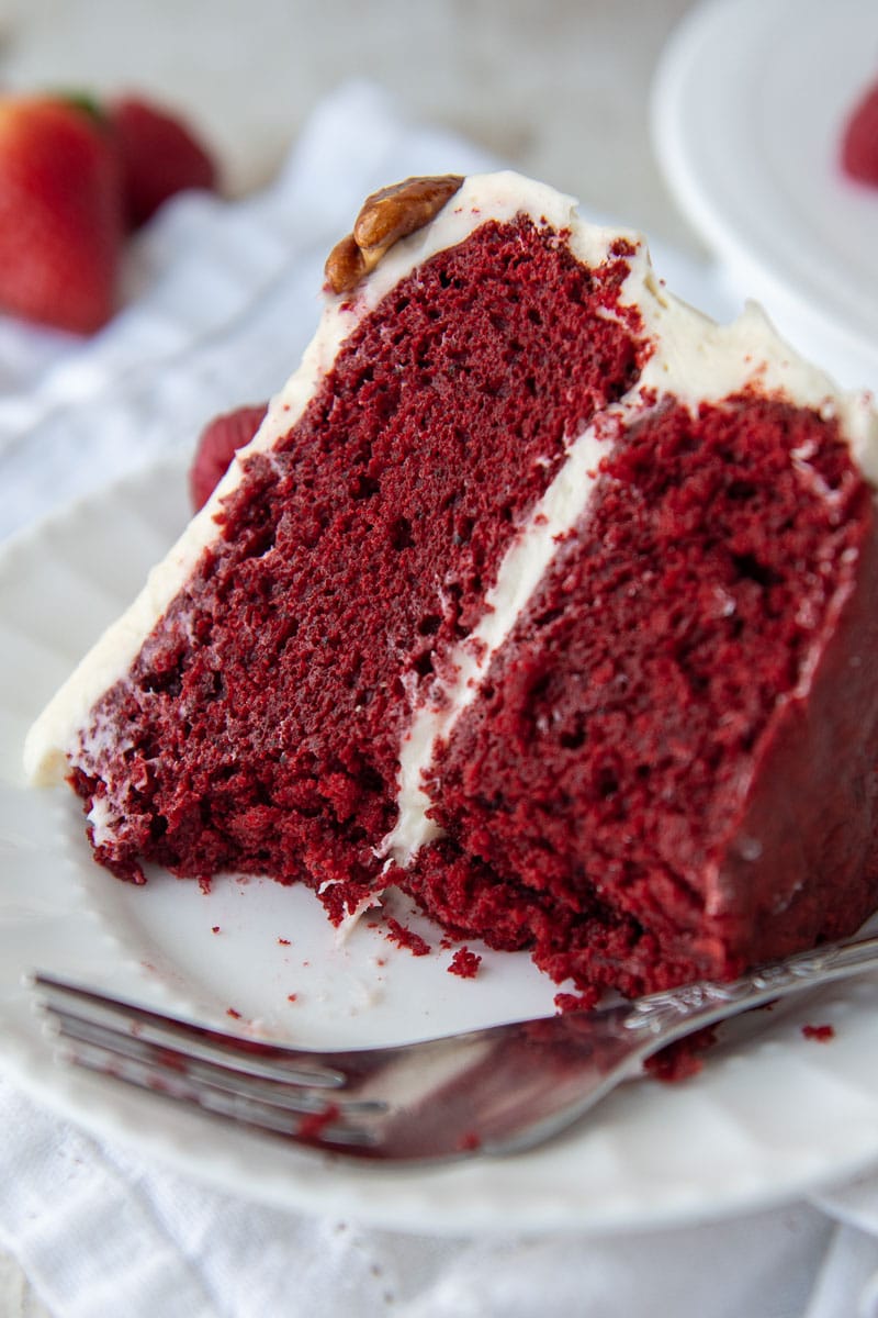 a slice of gluten free red velvet cake on a white plate with bites taken out