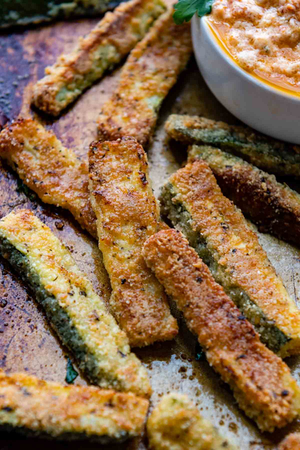 a close up of zucchini fries on a baking sheet.