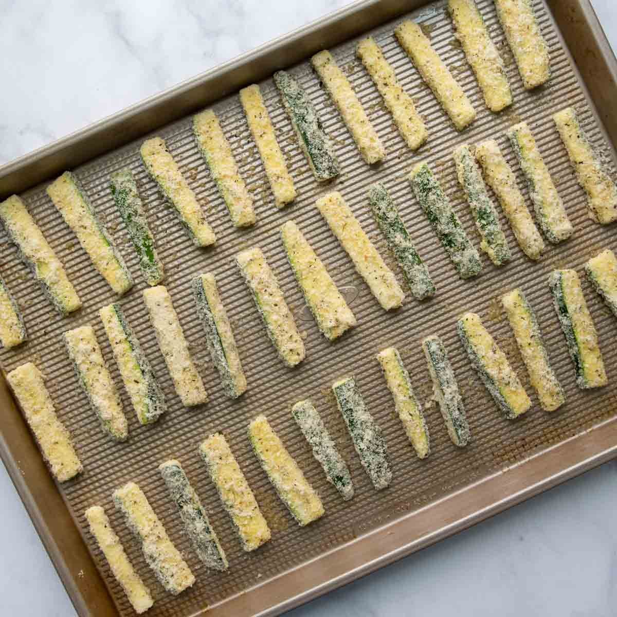 unbaked zucchini sticks on a baking sheet.