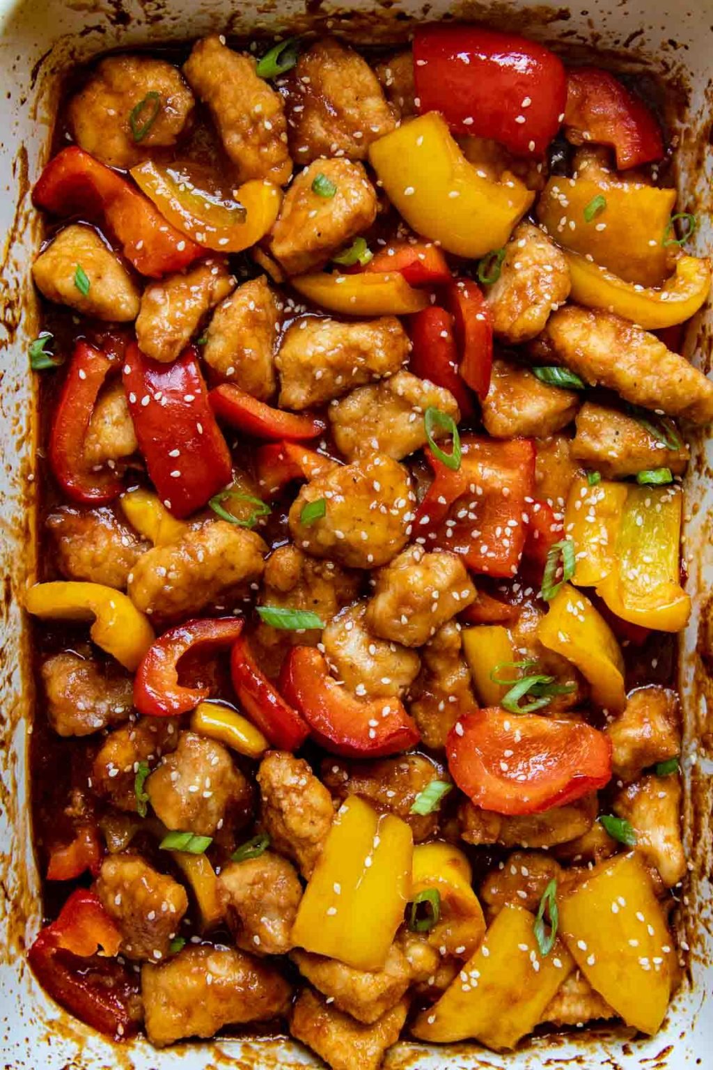 overhead shot of gluten free sweet and sour chicken in a white baking dish