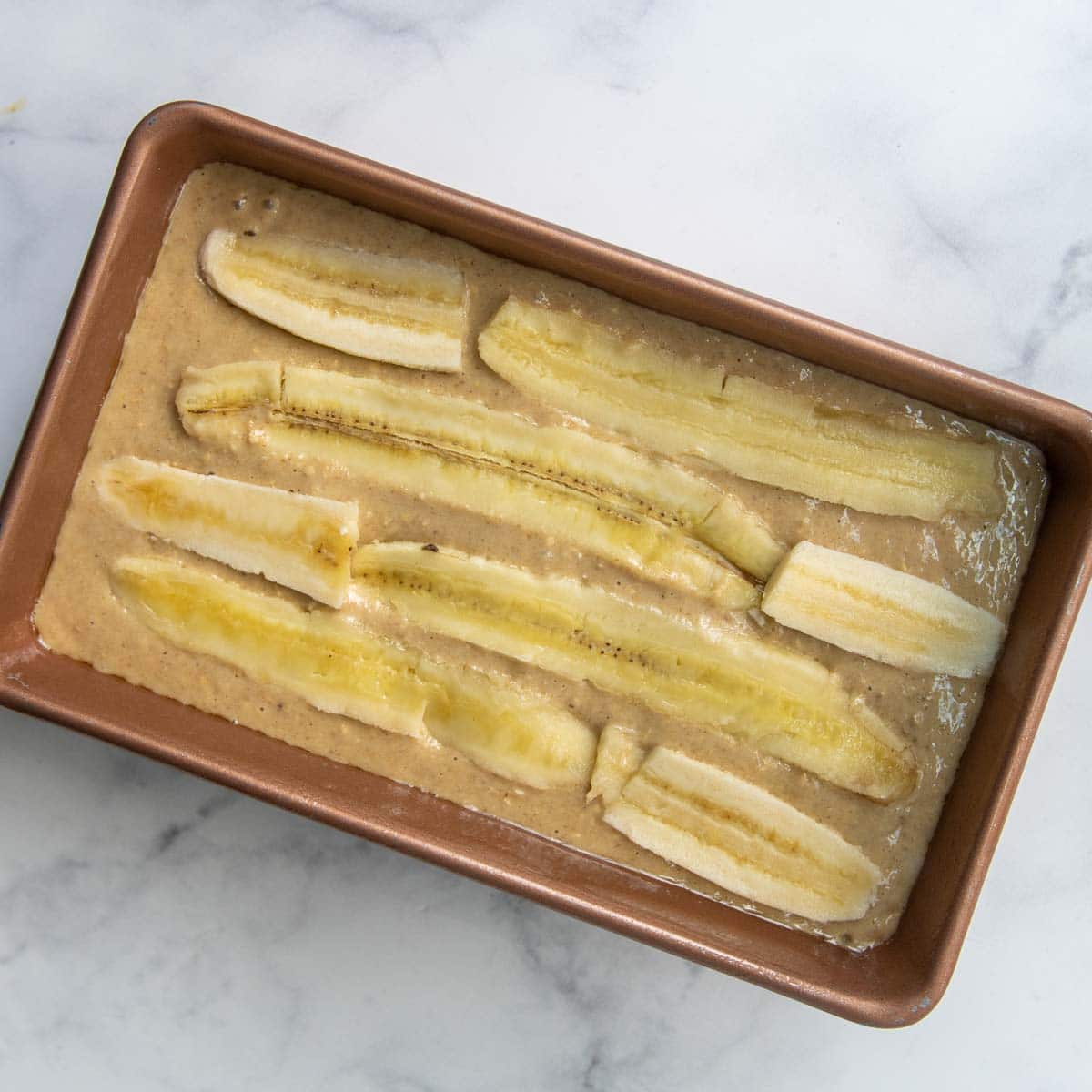 image showing unbaked bread with sliced bananas on top