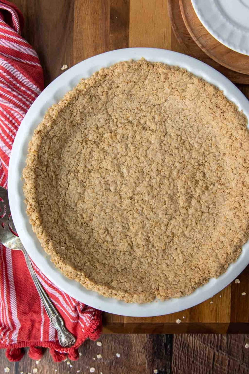 overhead shot of baked oatmeal pie crust in a white plate with a red linen next to it