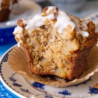 an apple muffin on a blue and white plate with a bite taken out