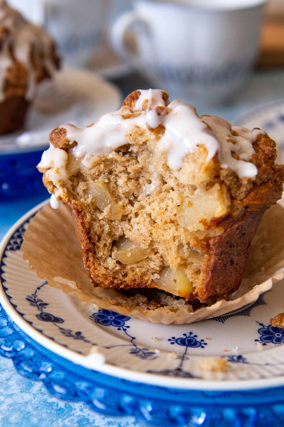 an apple muffin on a blue and white plate with a bite taken out