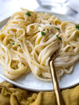 a fork wrapped around fettuccine alfredo