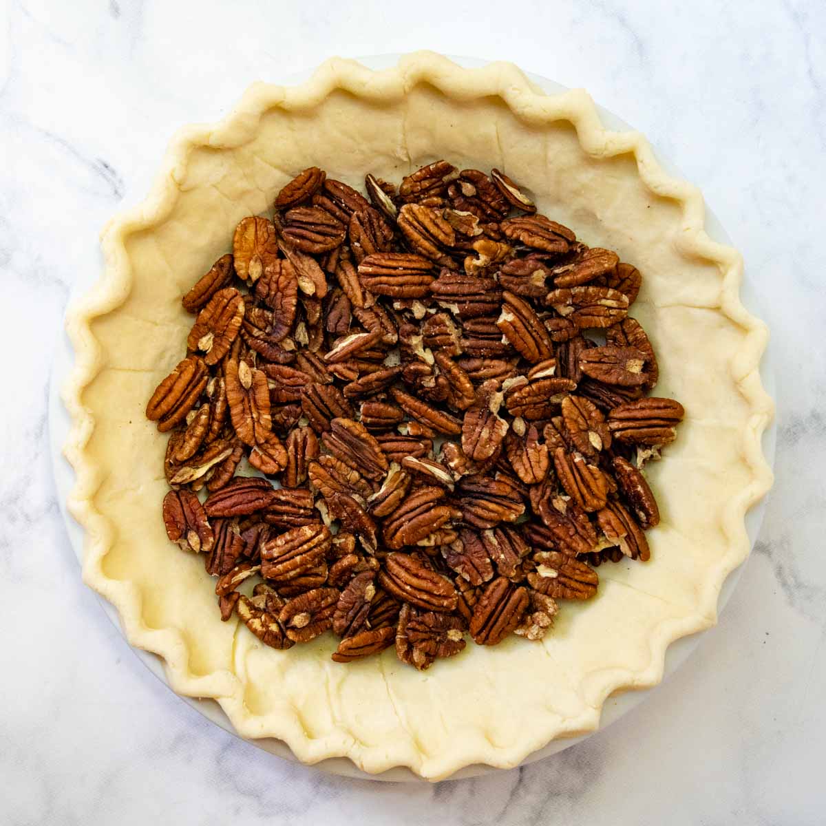 the pecans on the bottom of an unbaked pie crust.