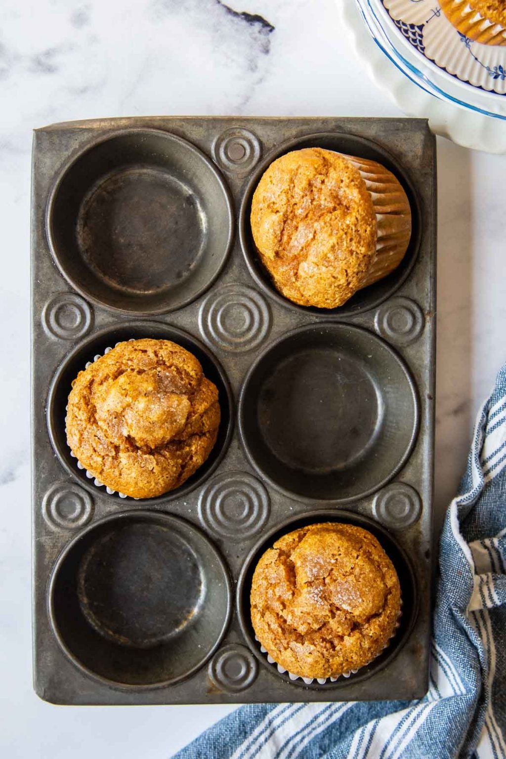 overhead shot of pumpkin oat flour muffins in a vintage muffin pan