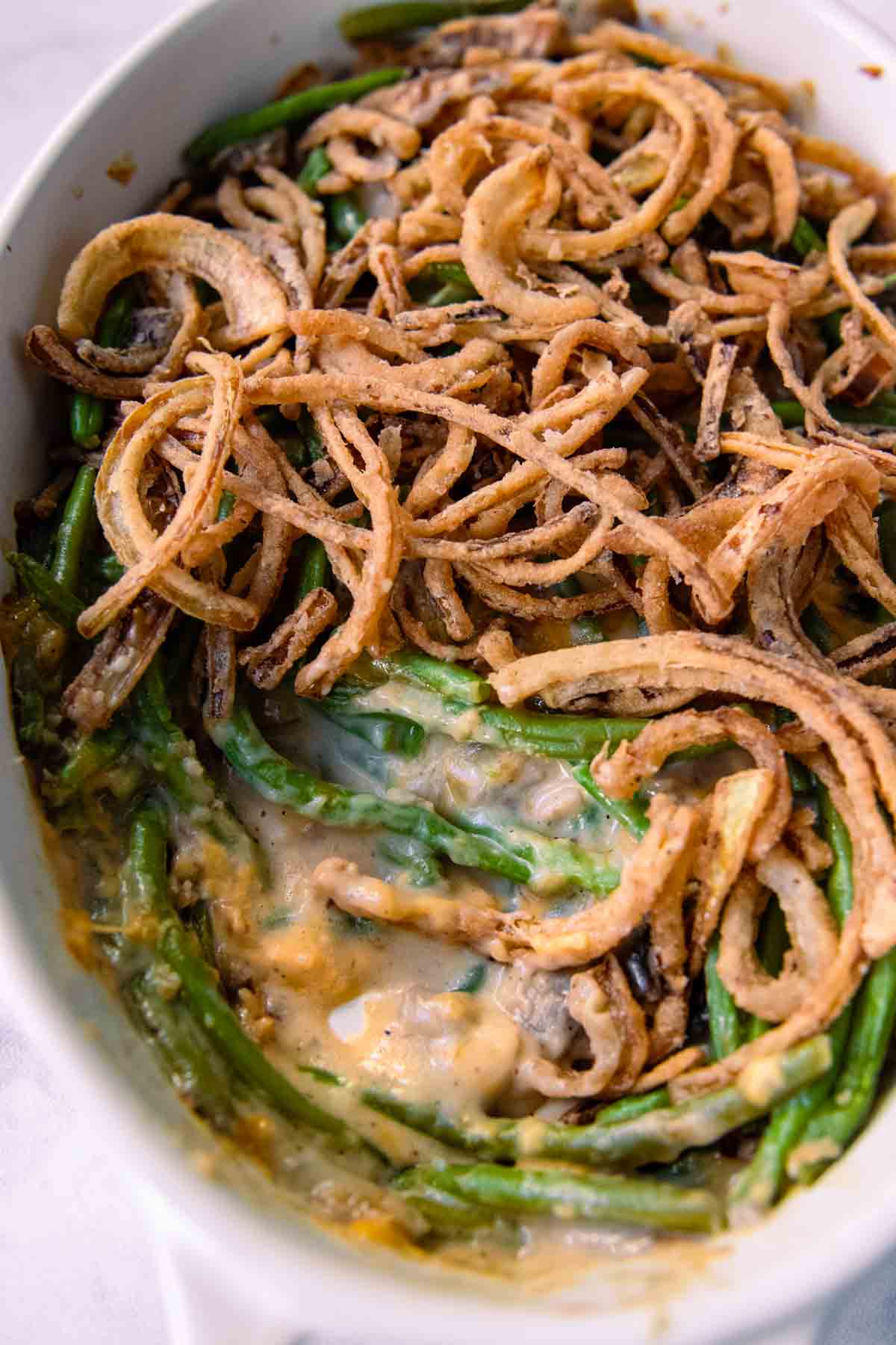 close up the inside of green bean casserole with fried onions on top